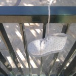 Sad things on the Streets of Paris, Petites chaussure de bébé perdue accrochée sur la porte d'un parc